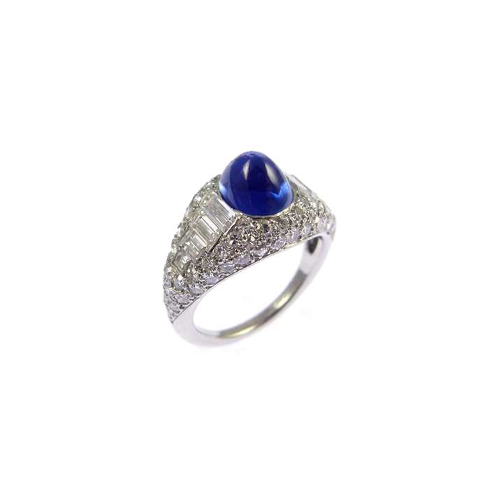 Cabochon sapphire and diamond cluster ring centred by an oval Kashmir sapphire